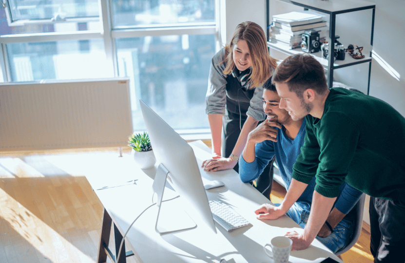 three coworkers looking at a laptop