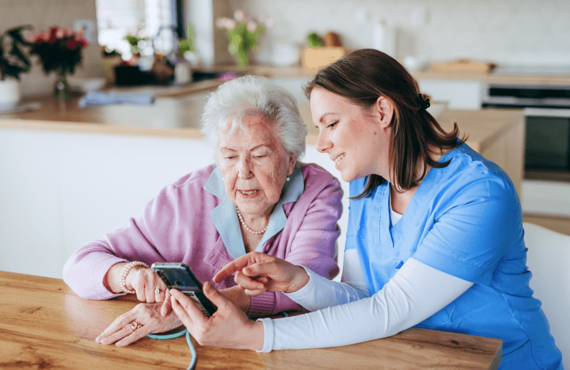 a woman showing her phone to an older woman