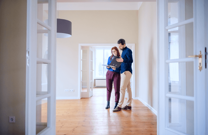 a couple looking at an album while standing on an empty room