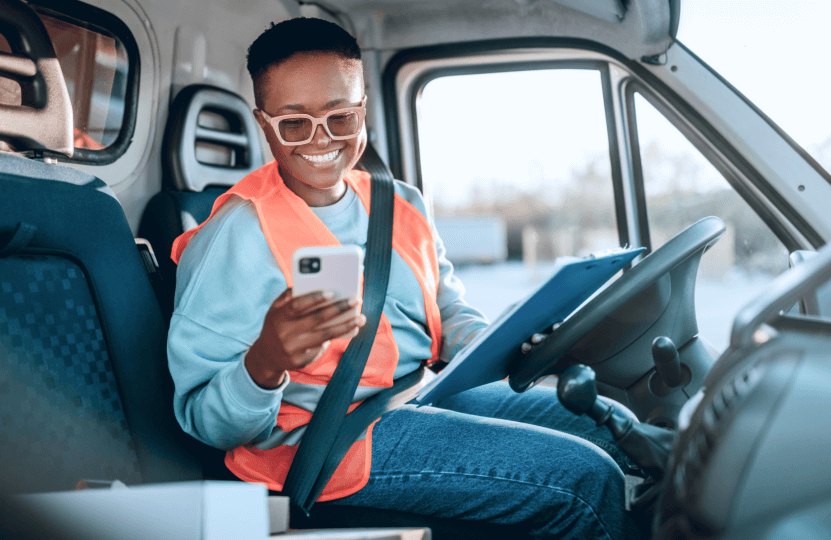 a woman driver looking at her phone inside her car