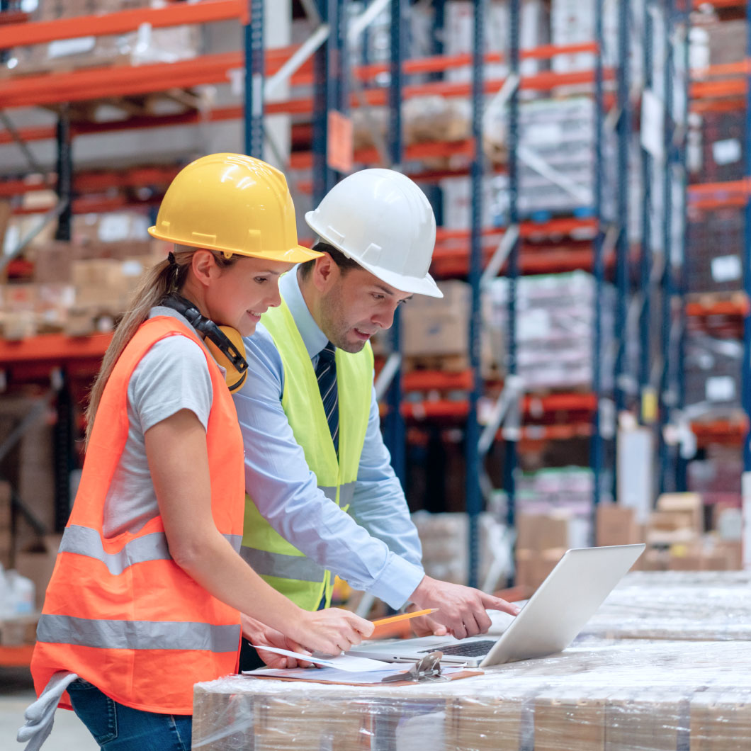 Two workers in helmets reviewing a document