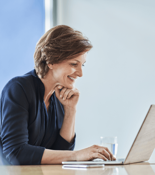 Woman smiling while working on her laptop